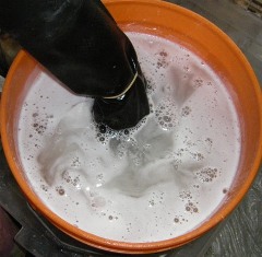 How to dip tie dye t-shirts into a soda ash water solution.